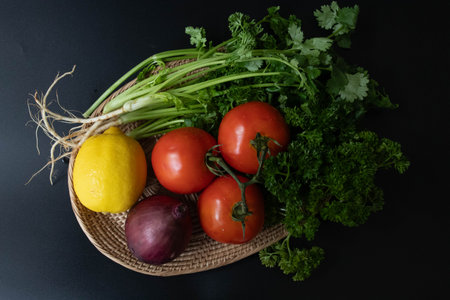 Fresh vegetables in a wicker basket on a black background. Top view.の写真素材