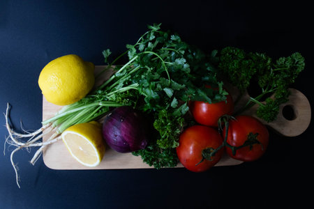Fresh vegetables on a cutting board on a black background. Healthy food.
