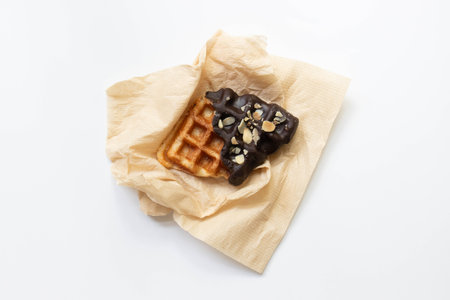 Belgian waffles with chocolate and nuts on a white background.の写真素材