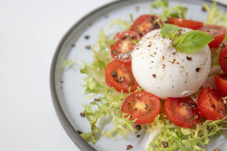 Caprese salad with tomatoes and Burrata cheese on white background