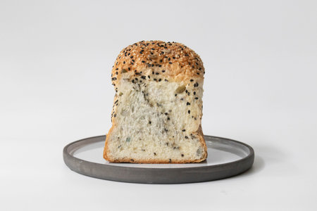 Bread with black sesame on a plate isolated on white backgroundの写真素材