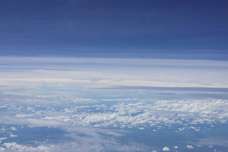 Clouds in the blue sky as seen through window of an aircraftの写真素材