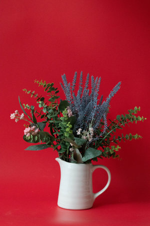Bouquet of dried flowers in a vase on a red backgroundの写真素材