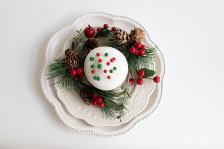 Chocolate Cupcake topped with red and green Christmas sprinkle , surrounded with red berries and green fir, White backgroundの写真素材