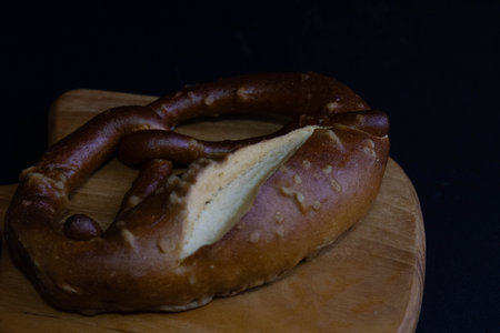 Salty pretzel on the wooden board, black backgroundの写真素材