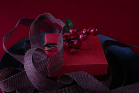 gift box with red ribbon on a black plate on a red background