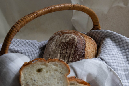 Fresh slices of multigrain bread arranged neatly on a wooden surface, partially wrapped in a soft...
