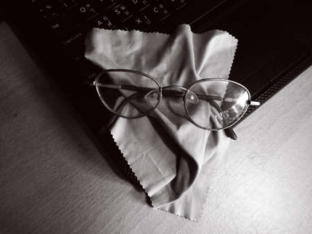 Eye glasses with cleaning cloth and laptop の写真素材
