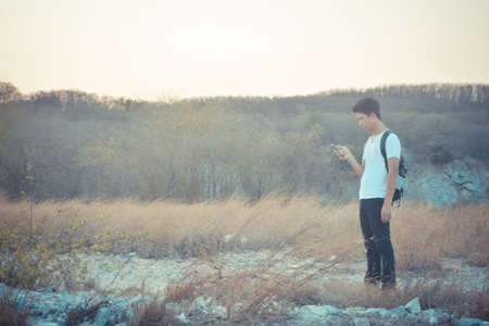 Lost man at the mountain looking for rescue from mobileの写真素材