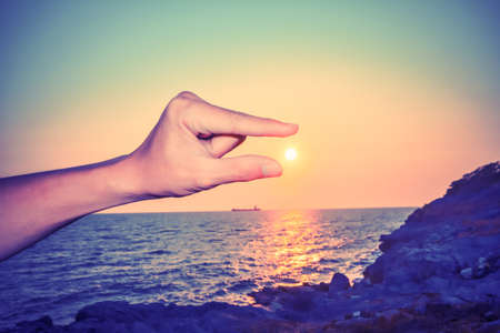 catching sun in the man's hand and fingersの写真素材