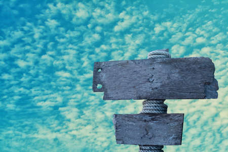 old gray wooden sign  with  blue sky backgroundの写真素材