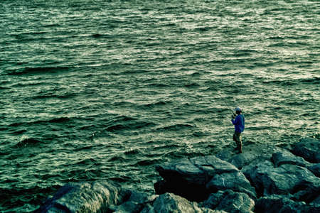 the fisherman  fishing   at the  stone  beach and the sea  の写真素材