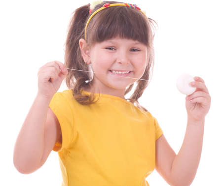 Beautiful little girl flossing her teethの写真素材