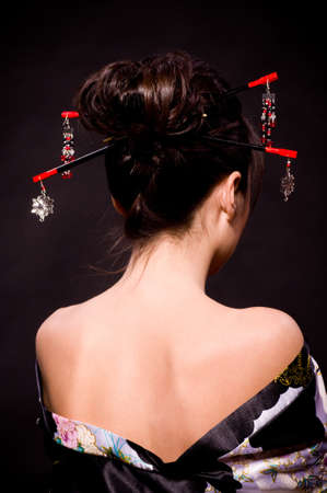 Beautiful young woman in Asian costume on black background.の写真素材