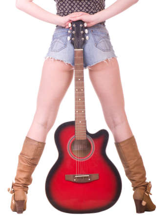 Beautiful womanish legs with guitar on a white backgroundの写真素材