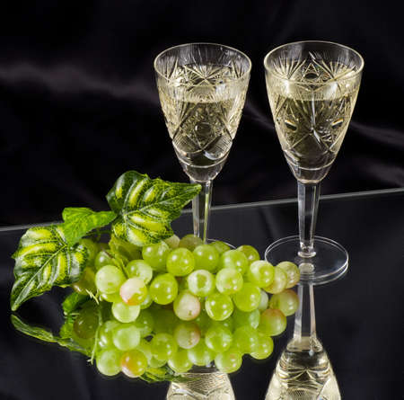 White wine in glass with grape on black backgroundの写真素材
