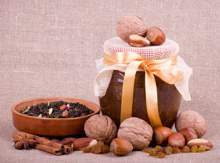 Beautiful jam, cupcakes, tea and nuts on backgroundの写真素材