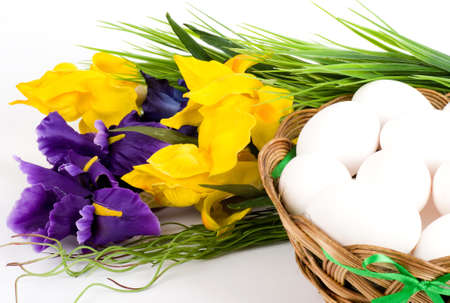 Basket with Easter eggs and spring tulips on white backgroundの写真素材