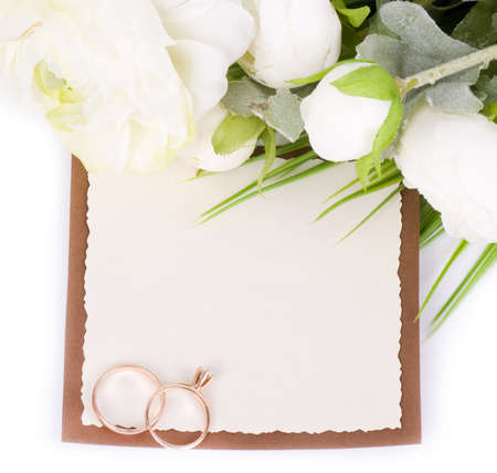 Gold wedding rings on a bouquet of white roses with banner addの写真素材