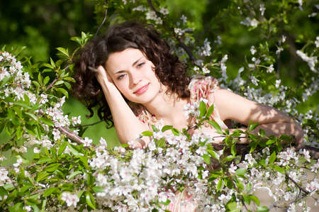 Beautiful woman in spring flowersの写真素材