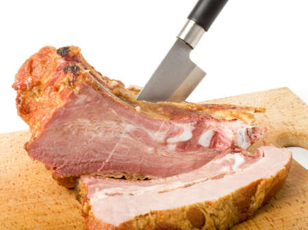 Tasty smoked meat with knife on a white background