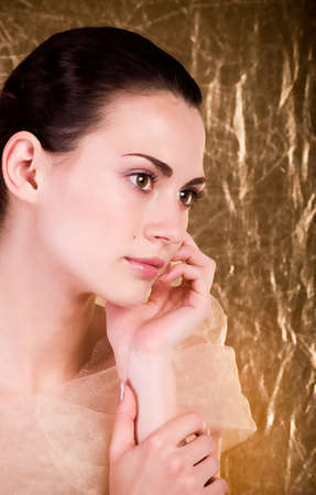 Beautiful young woman on golden backgroundの写真素材