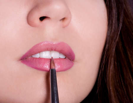 Young woman applying lipstick  Professional Make-upの写真素材