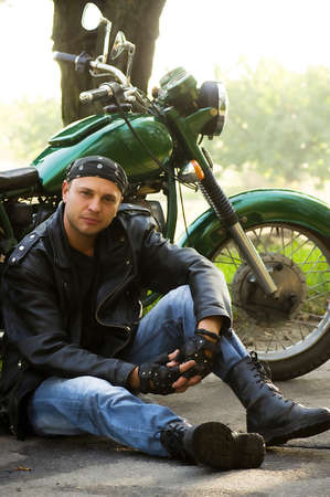 Man sitting by motorcycle