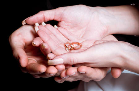 Newly wed bride and groom holding hands ringsの写真素材