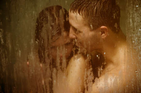 Loving couple engaged in love in a bath boothの写真素材