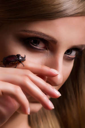 Portrait of beautiful young woman with beetleの写真素材