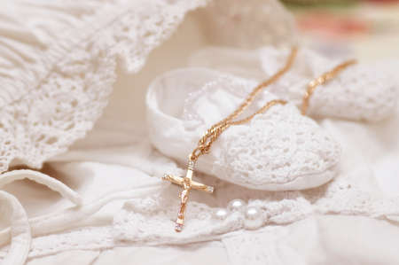 Baby shoe and card with golden cross for Christeningの写真素材