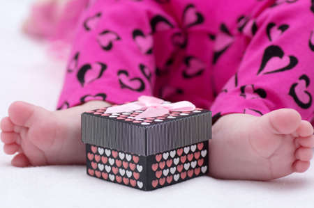 Baby girl feet with gift boxの写真素材