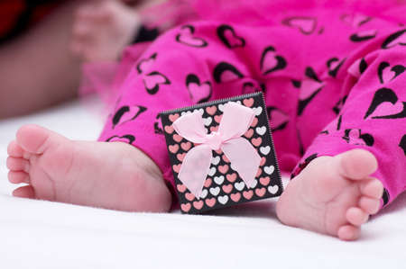 Baby girl feet with gift boxの写真素材