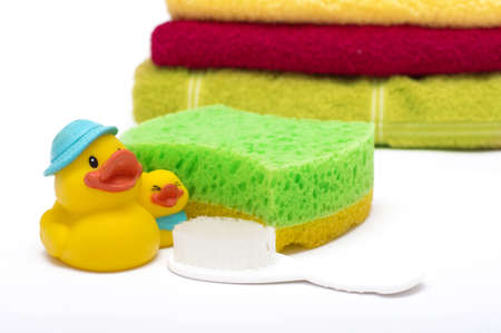 Bath sponge, towels and rubber duck on white backgroundの写真素材