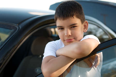 Image of a cute young boy driving a black car