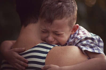 boy and soldier in a military uniform say goodbye before a separationの写真素材