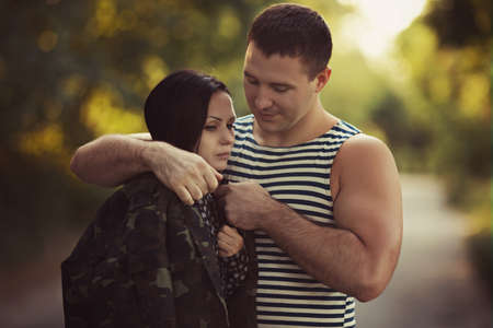 Woman and soldier in a military uniform say goodbye before a separationの写真素材
