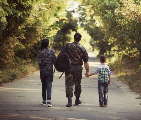 Family and soldier in a military uniform say goodbye before a separationの写真素材