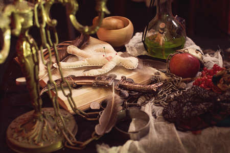 Voodoo gypsy putting needles in a doll casting a spell or curse. Halloween backgroundの写真素材
