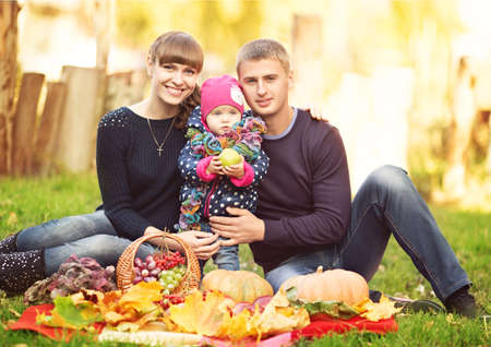 Pretty smiling family and daughter in autumn parkの写真素材