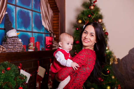 Beautiful mother with baby girl near a Christmas treeの写真素材