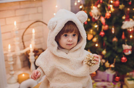 Beautiful baby girl near a Christmas tree with giftsの写真素材