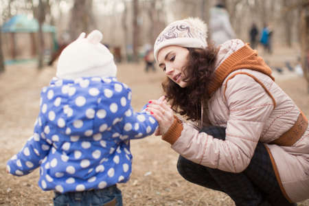 Funny little girl and mother in spring forestの写真素材