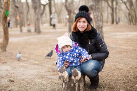 Funny little girl and mother in spring forestの写真素材