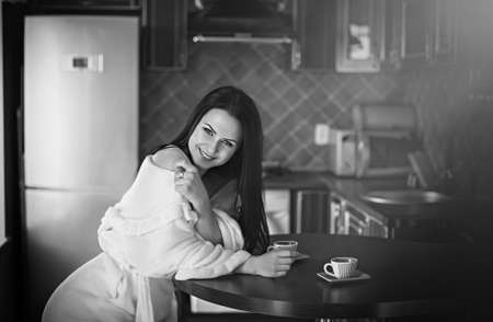 Beautiful sexy woman with coffee in the kitchenの写真素材