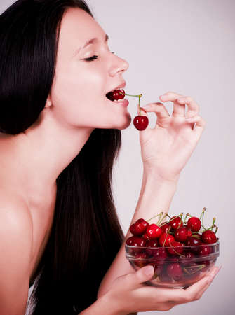 Woman with cherries on backgroundの写真素材