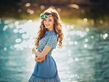beautiful young girl with long dark hairs on the riversideの写真素材