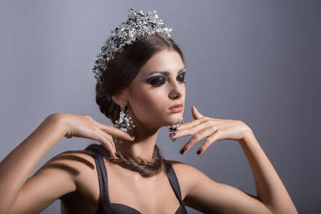 Beautiful woman model with professional makeup, in jewelry. Golden crownの写真素材