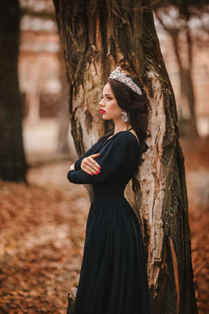 Beautiful woman model with professional makeup, in jewelry. Golden crown in styleの写真素材